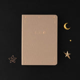 Tsuki Stardust Dawn Bullet Journal with rose gold details and powdered lilac linen on black background