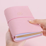Tsuki ‘Sakura Journey’ Limited Edition Travel Notebook held in hands at an angle in pink background