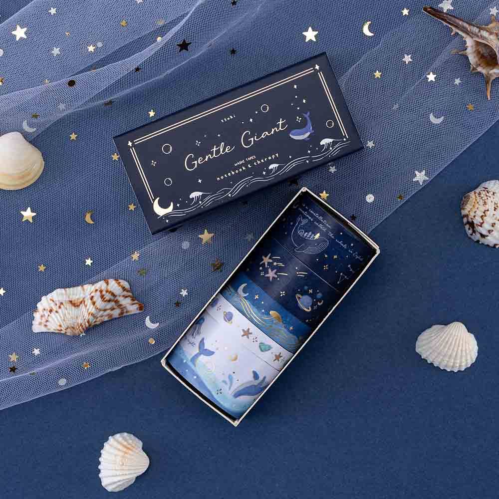 Tsuki Gentle Giant washi tapes on deep blue background and white net + seashells scattered around the washi tape set