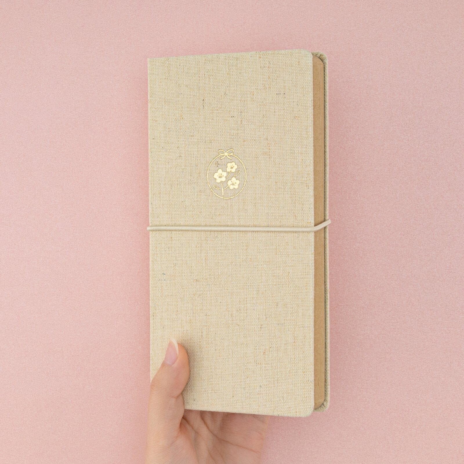 Hand holding Tsuki ‘Sakura Breeze’ Kraft Paper Travel Notebook at an angle