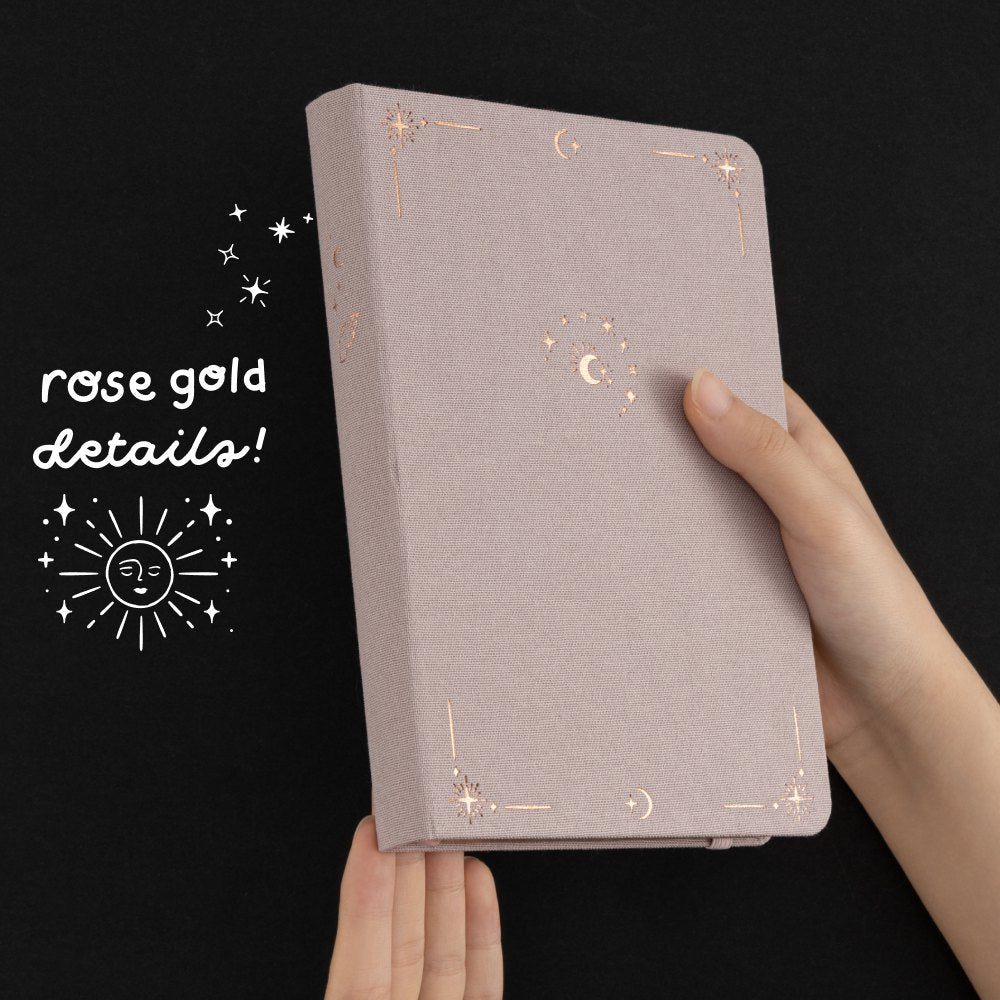 Hands holding Tsuki Moonlit Dusk Bullet Journal showing rose gold details