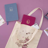 Kyoto notebook and iPhone peeking out of a Kyoto tote bag