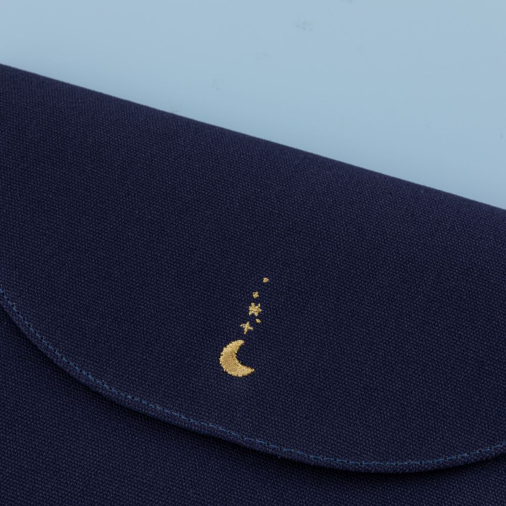 Close up of the embroidered moon detail on the notebook pouch flap