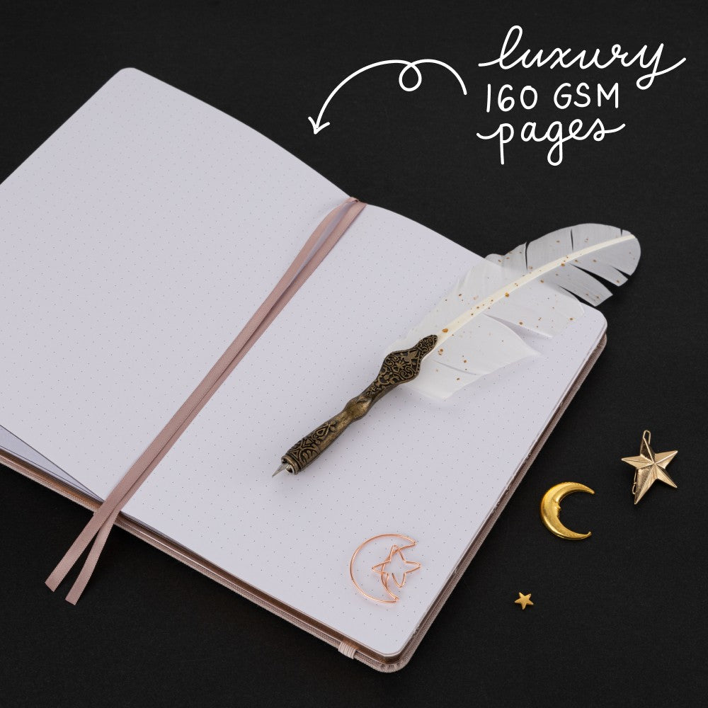 Hand opening the back pocket of Tsuki Moonlit Dusk Bullet Journal with rose gold moon-shaped paperclip inside