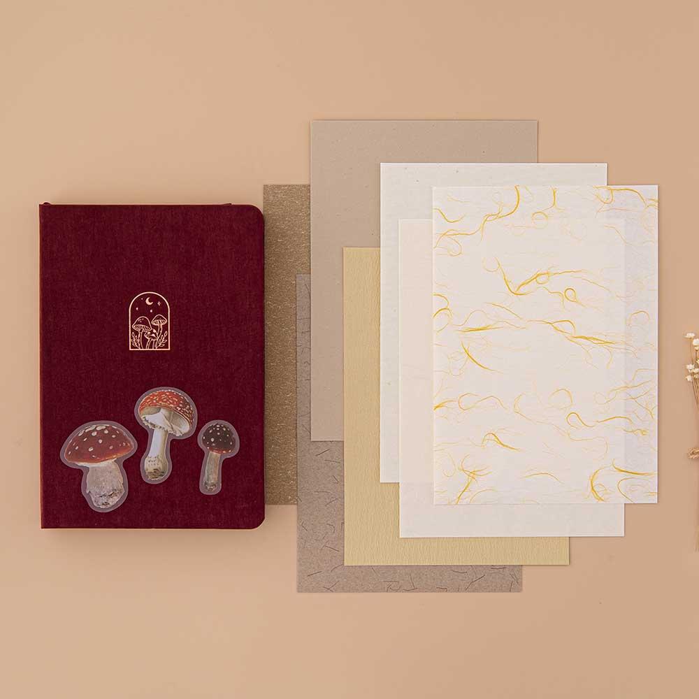 Tsuki Mixed Scrapbook Paper Pack with free mushroom stickers and Tsuki ‘Kinoko’ Limited Edition Bullet Journal on beige background