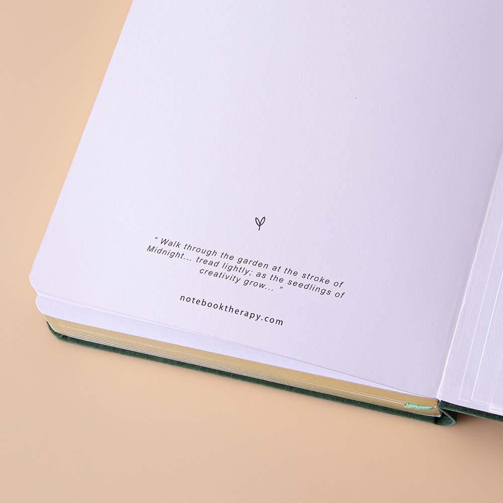Close up of open back page of Tsuki ‘Midnight Garden’ Limited Edition Bullet Journal on beige background