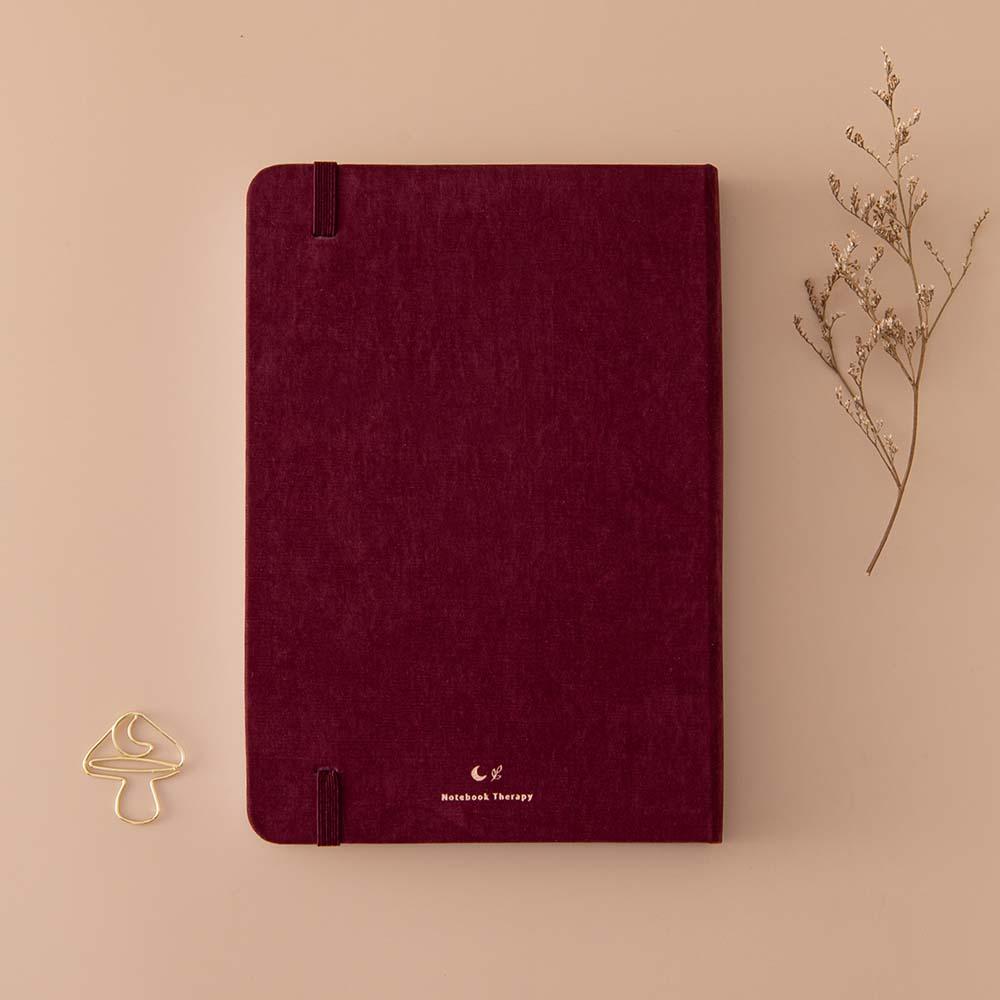 Back cover of Tsuki ‘Kinoko’ Limited Edition Bullet Journal with free paperclip gift with dried flowers on beige background