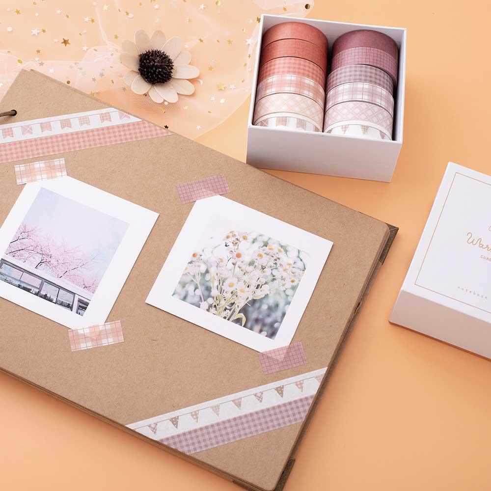 Tsuki Core Washi Tape Set in Warm Neutral with luxury eco-friendly gift box packaging and flowers on open scrapbook page with netting on orange peach background