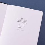 Close up of the open front page of Tsuki ‘Winter Journey’ Limited Edition Bullet Journal on navy background