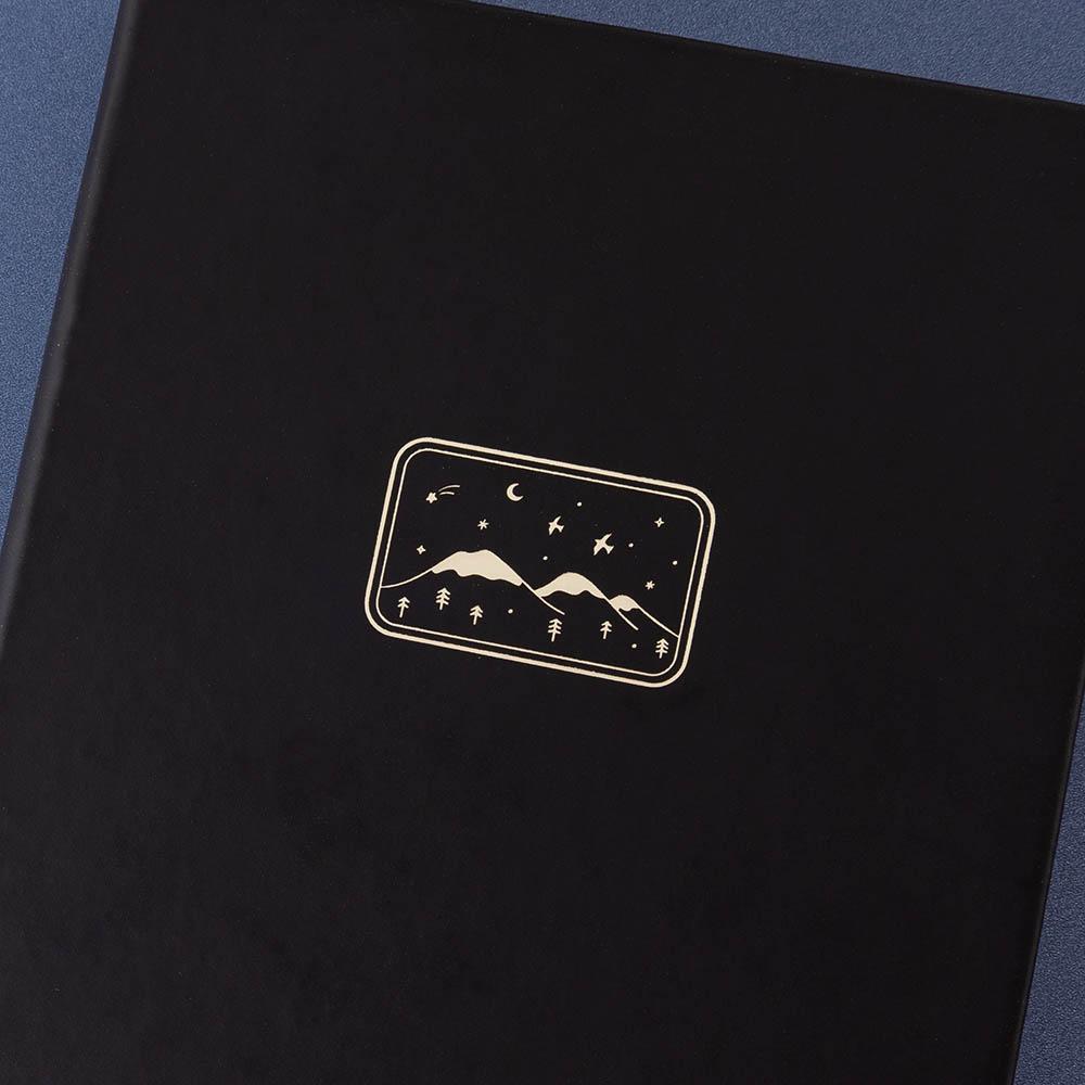 Close up of the front cover of Tsuki ‘Winter Journey’ Limited Edition Bullet Journal on navy background
