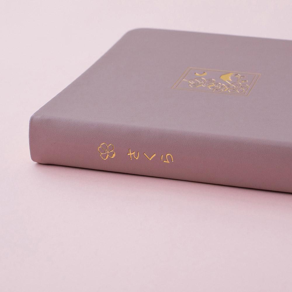 Side of blush pink bullet journal notebook on a pink background