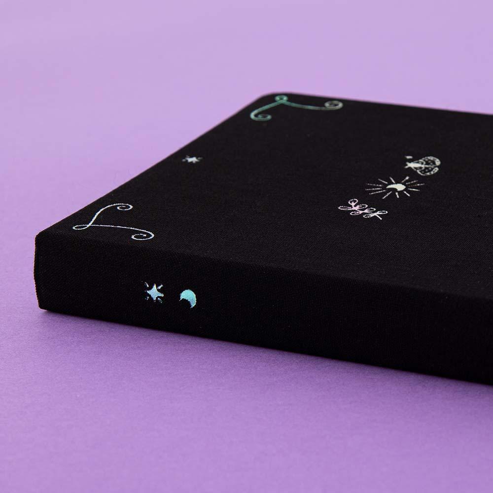 Close up of Tsuki ‘Moonlit Spell’ Limited Edition Holographic Bullet Journal on purple background
