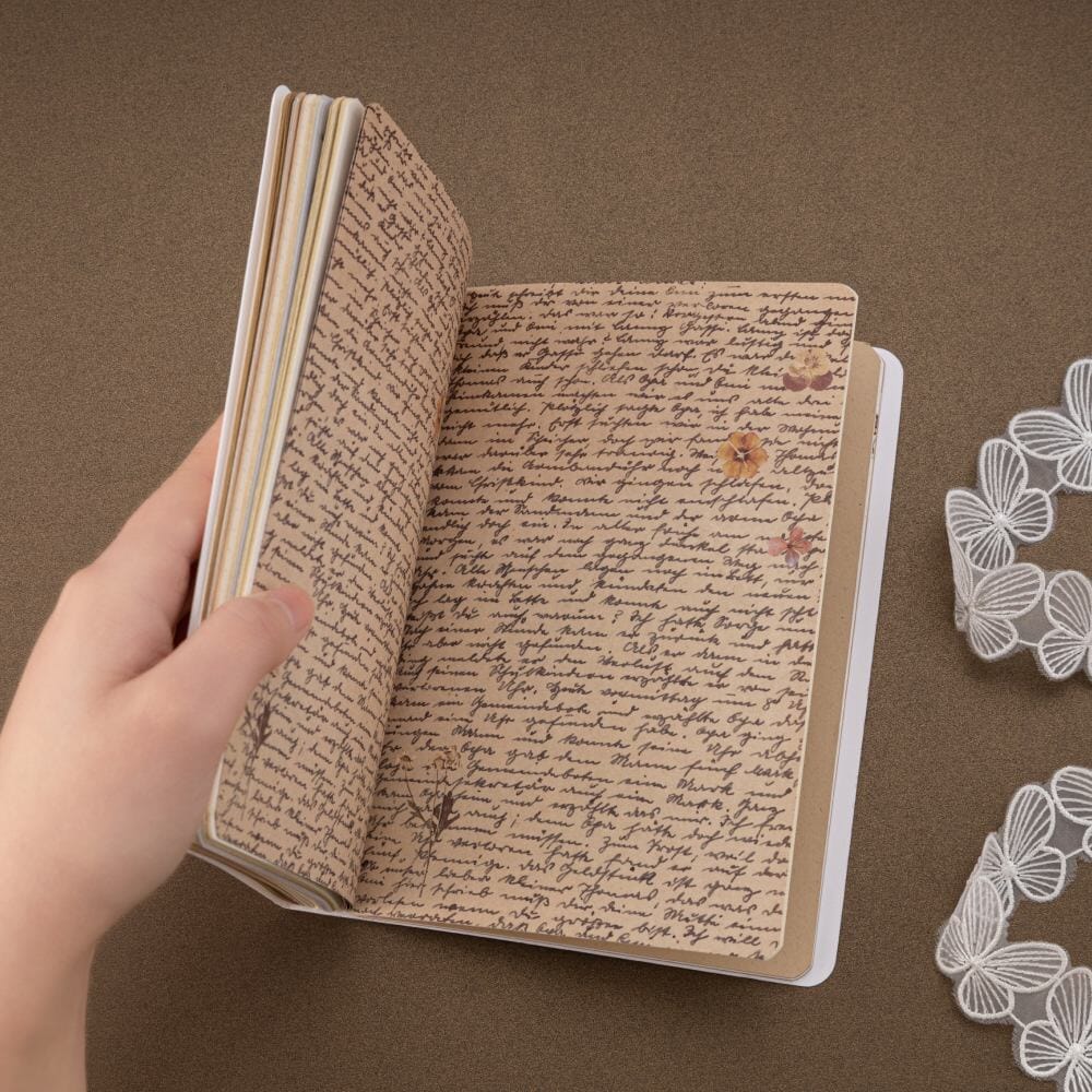 Printed pages with handwriting and flower petals