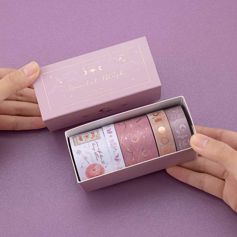 Close up of Tsuki ‘Moonlit Blush’ Washi Tape Set held in hands in purple background