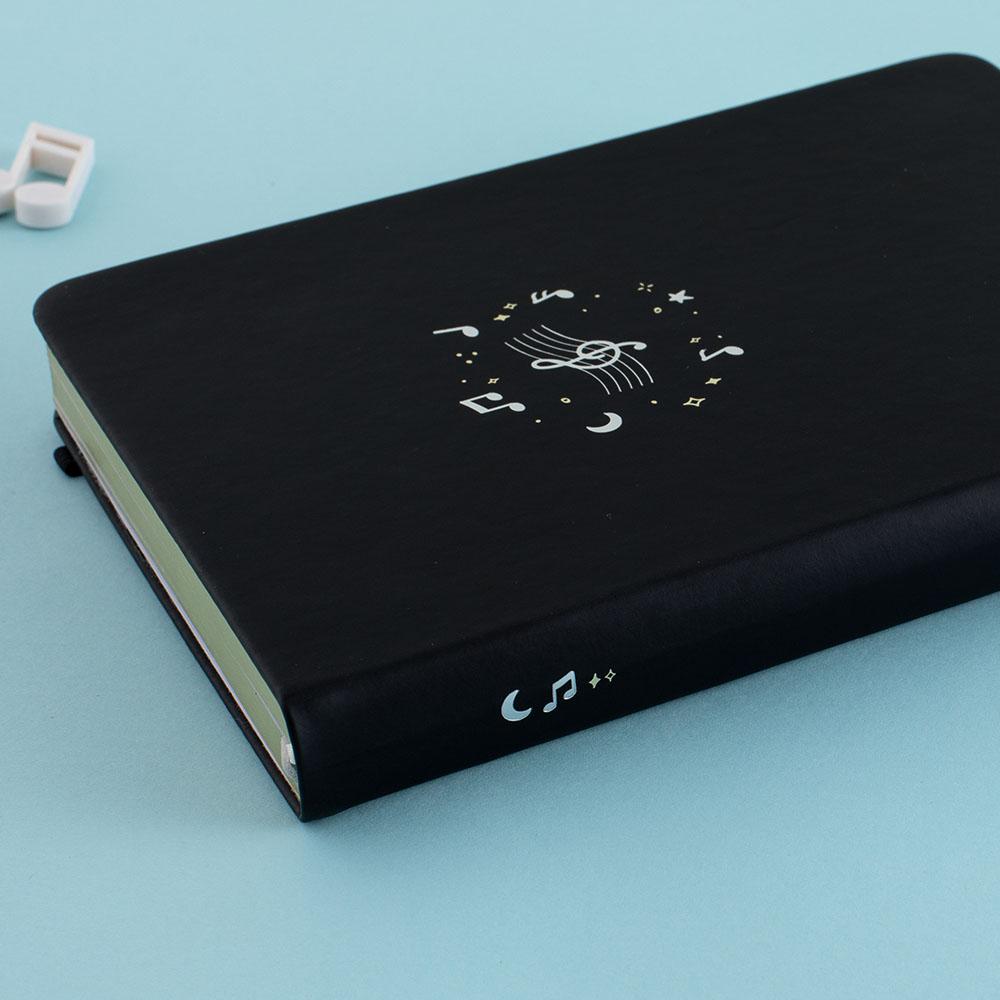 Close up of Tsuki Lunar Notes bullet journal spine detail image on blue background