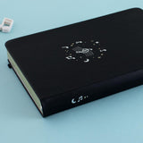 Close up of Tsuki Lunar Notes bullet journal spine detail image on blue background