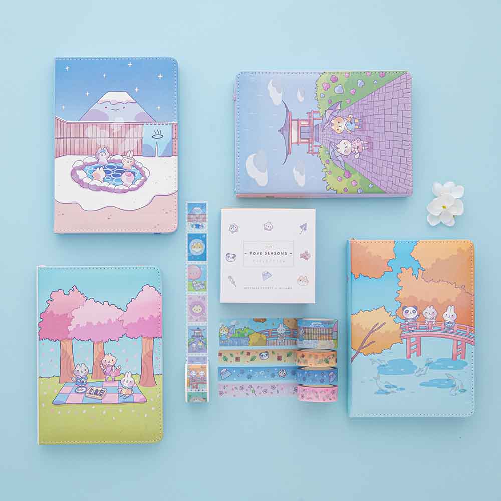 Tsuki ‘Four Seasons’ Washi Tape Set by Notebook Therapy x Milkkoyo with Tsuki ‘Four Seasons: Winter Edition’ Bullet Journal and Tsuki ‘Four Seasons: Spring Edition Bullet Journal and Tsuki ‘Four Seasons: Summer Edition’ Bullet Journal and Tsuki ‘Four Seasons: Autumn Edition’ Bullet Journal with white flower on light blue background