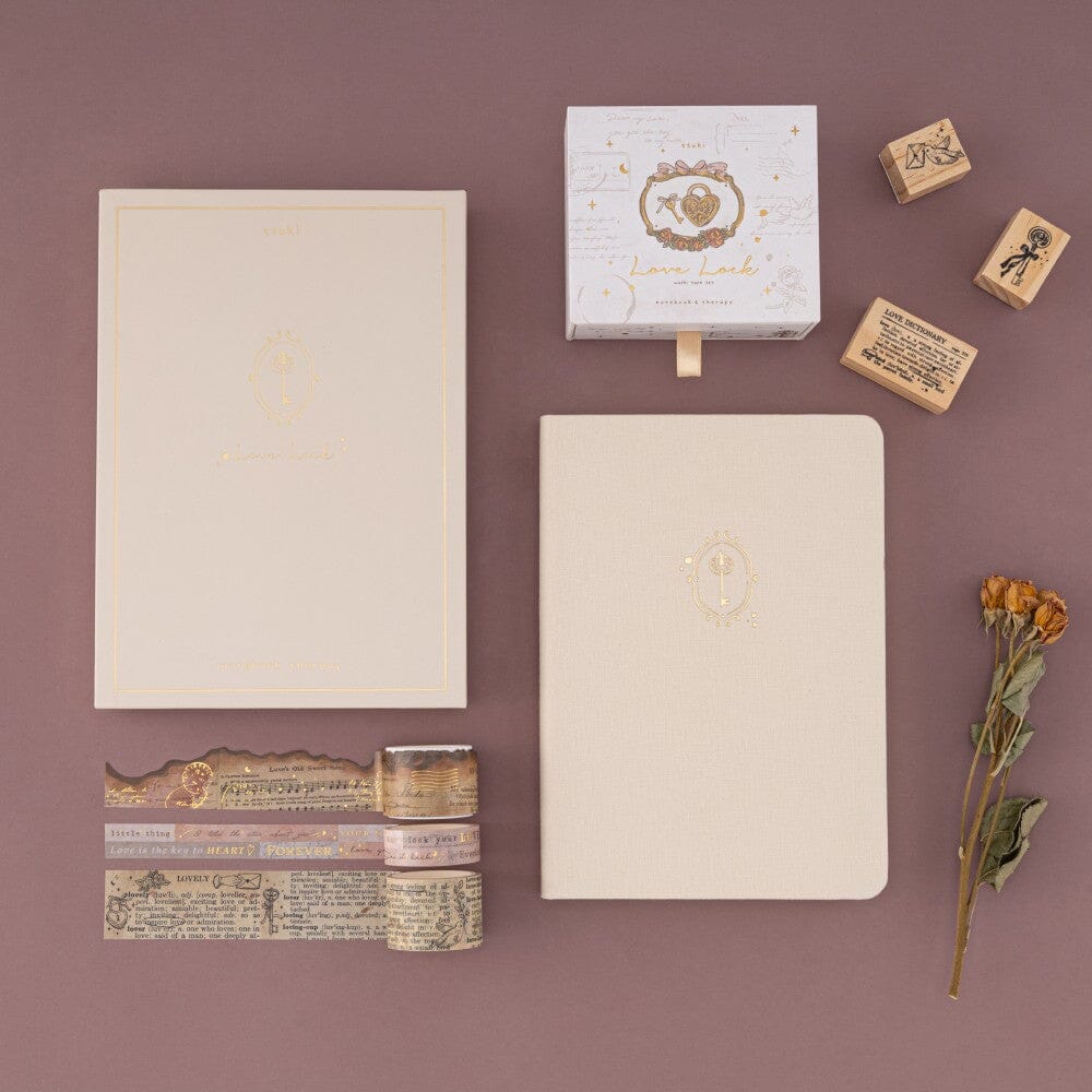 Flatlay of bullet journal notebook aand washi tape set with a couple of stamps on the side