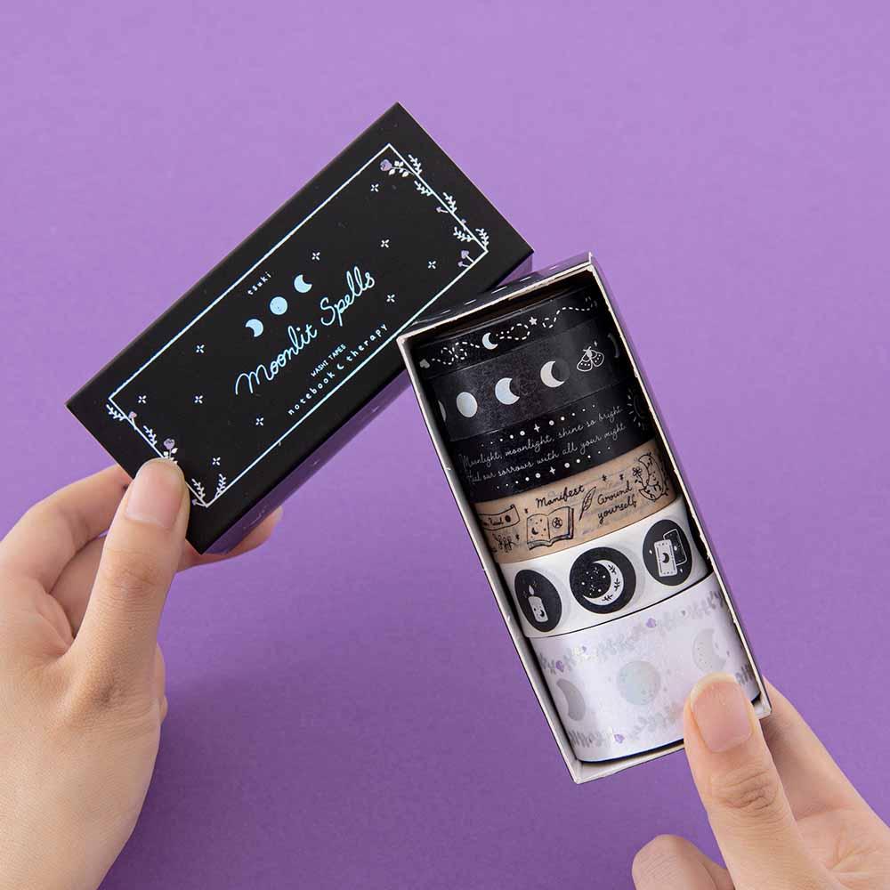Tsuki ‘Moonlit Spell’ Washi Tape Set held in hands in purple background