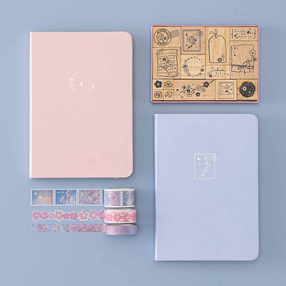 Tsuki ‘Sakura Journey’ Bullet Journal Stamp Set with Tsuki ‘Lunar Blossom’ Limited Edition Bullet Journal and Tsuki ‘Sakura Journey’ Limited Edition Bullet Journal and Tsuki ‘Sakura Journey’ Washi Tape Set on light blue background
