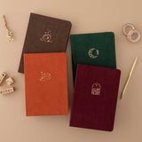Tsuki ‘Kitsune’ Limited Edition Fox Bullet Journal and Tsuki ‘Nara’ Limited Edition Bullet Journal and Tsuki ‘Kinoko’ Limited Edition Bullet Journal and Tsuki ‘Midnight Garden’ Limited Edition Bullet Journal with Tsuki ‘Maple Dreams’ Washi Tapes and Tsuki ‘Maple Dreams’ Bullet Journal Stamps with gold pen and dried flowers on beige background