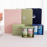 Tsuki ‘Ichigo’ Limited Edition Boba Bullet Journal and Tsuki ‘Matcha Matcha’ Limited Edition Bullet Journal and Tsuki ‘Matcha Ichigo’ Washi Tape Set and Tsuki ‘Cup of Galaxy’ Limited Edition Holographic Bullet Journal and Tsuki ‘Cup of Galaxy’ Washi Tape Set with strawberry bubble tea on linen covered table