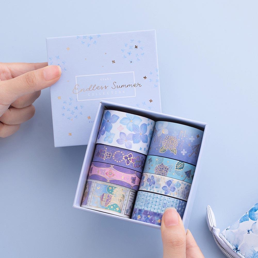 Tsuki Endless Summer Washi Tape Set with eco-friendly gift box packaging held in hands with Tsuki Endless Summer Pop Up Pencil case in petal blue on light blue background