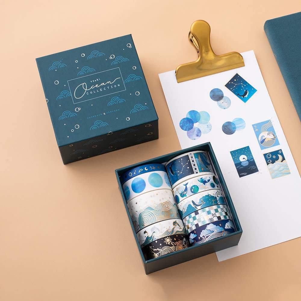 Tsuki Ocean Edition Washi Tapes and sticker sheet set on clipboard with reusable eco-friendly gift box on peach background