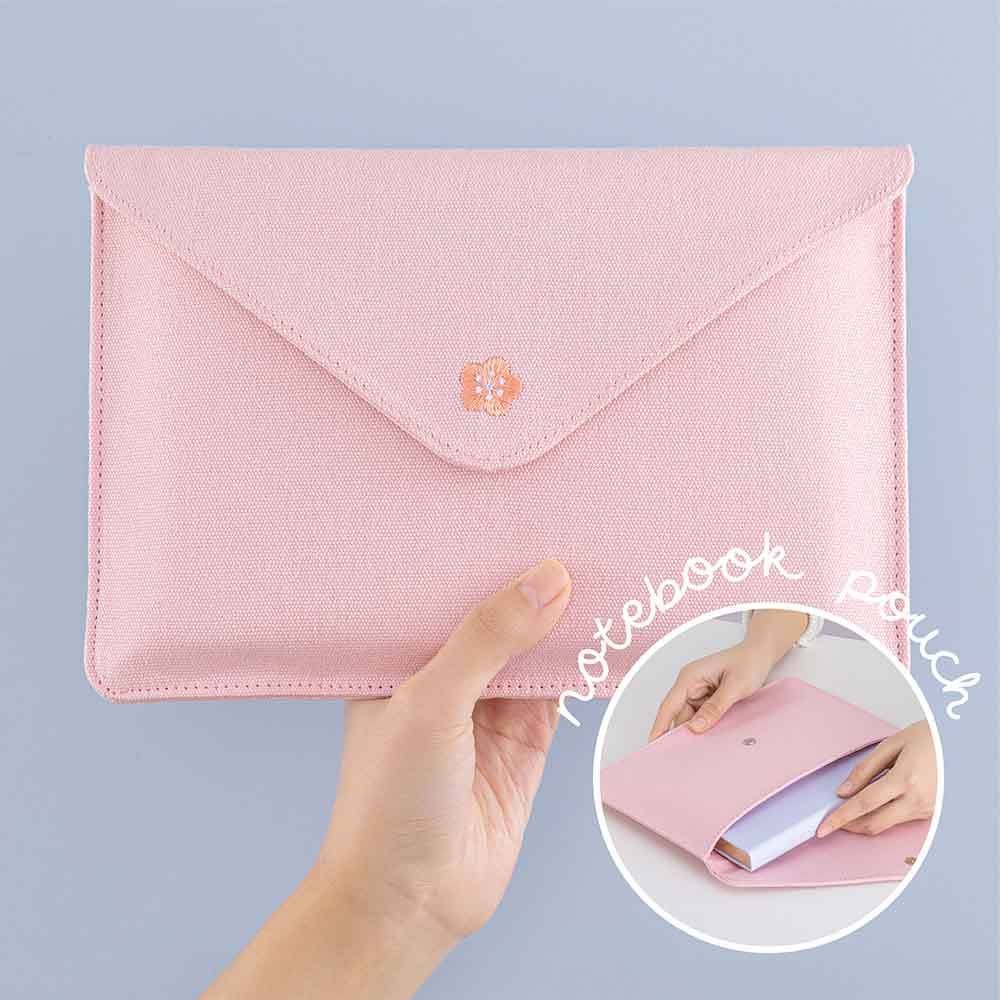 Tsuki ‘Sakura Journey’ Notebook Pouch held in hand in light blue background