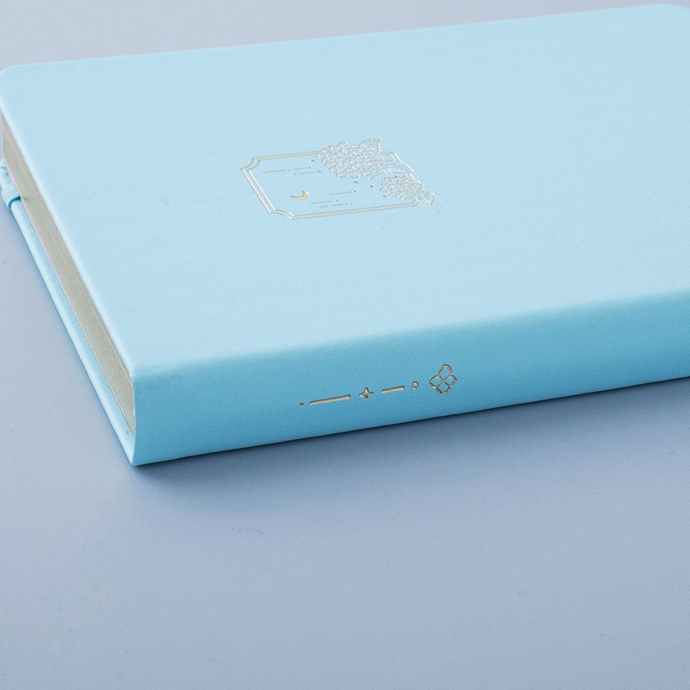 Close up of Tsuki Endless Summer Limited Edition Bullet Journal in Petal Blue on light blue background