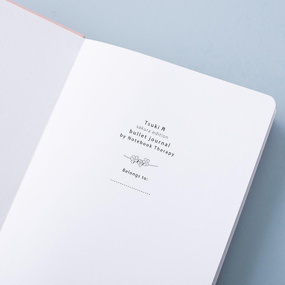 Open front page of Tsuki 'Sakura' Limited Edition Bullet Journal on light blue background