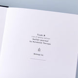 Close up of the open front page of Tsuki ‘Cup of Galaxy’ Limited Edition Holographic Bullet Journal on light blue background