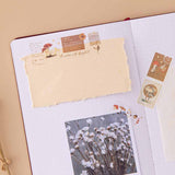 Tsuki Mixed Scrapbook Paper torn and stuck onto open bullet journal page with polaroid picture and Tsuki ‘Maple Dreams’ Washi Tapes on beige background