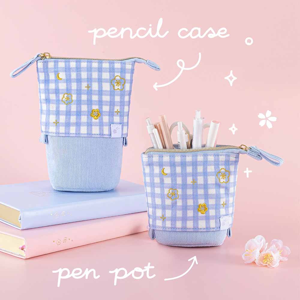 Two Tsuki ‘Sakura Journey’ Pop-Up Pencil Cases as pen pot and pencil case with pens inside with Tsuki ‘Sakura Journey’ Limited Edition Bullet Journal and Tsuki ‘Lunar Blossom’ Limited Edition Bullet Journal with cherry blossoms in light pink background