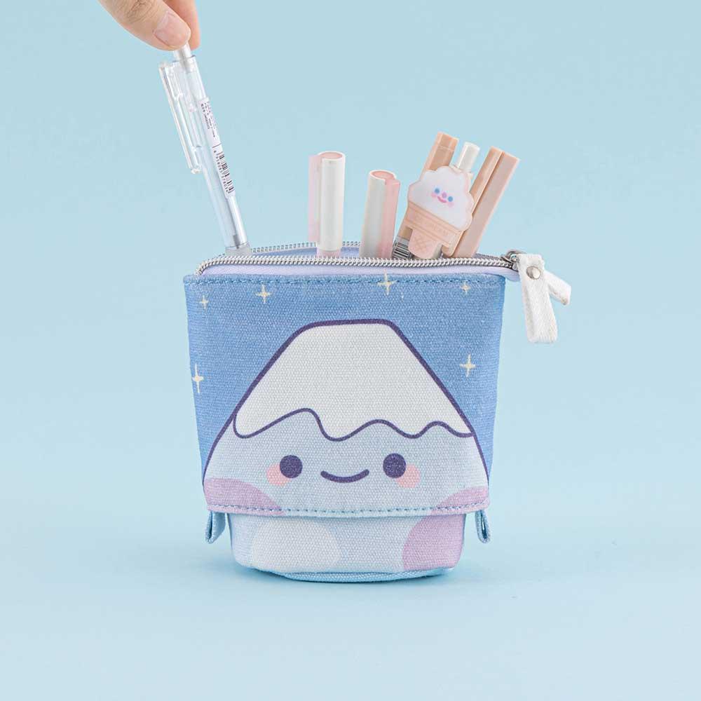 Tsuki ‘Four Seasons’ Fuji Pop-Up Pencil Case by Notebook Therapy x Milkkoyo with pens inside held in hand in light blue background