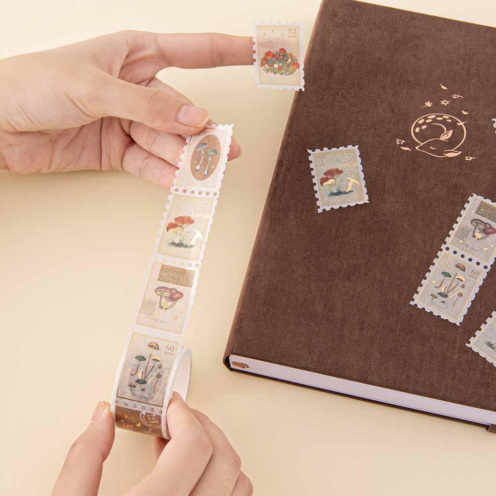 Close up of Tsuki ‘Maple Dreams’ Stamp Washi Tape held in hands with Tsuki ‘Nara’ Limited Edition Bullet Journal on cream background