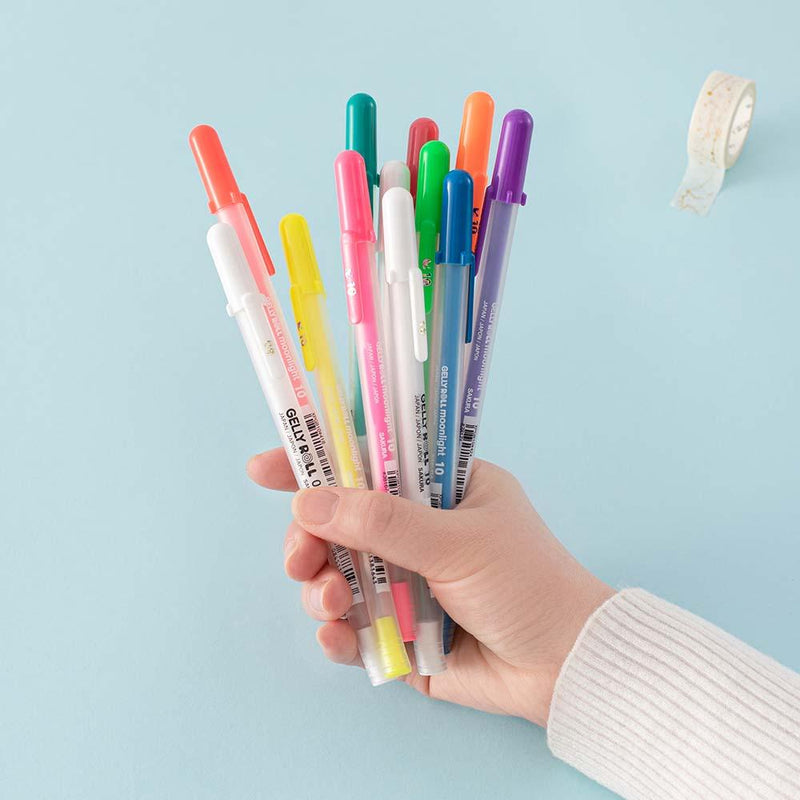 Gelly Roll Pens held in hand with Tsuki Washi Tape in light teal background