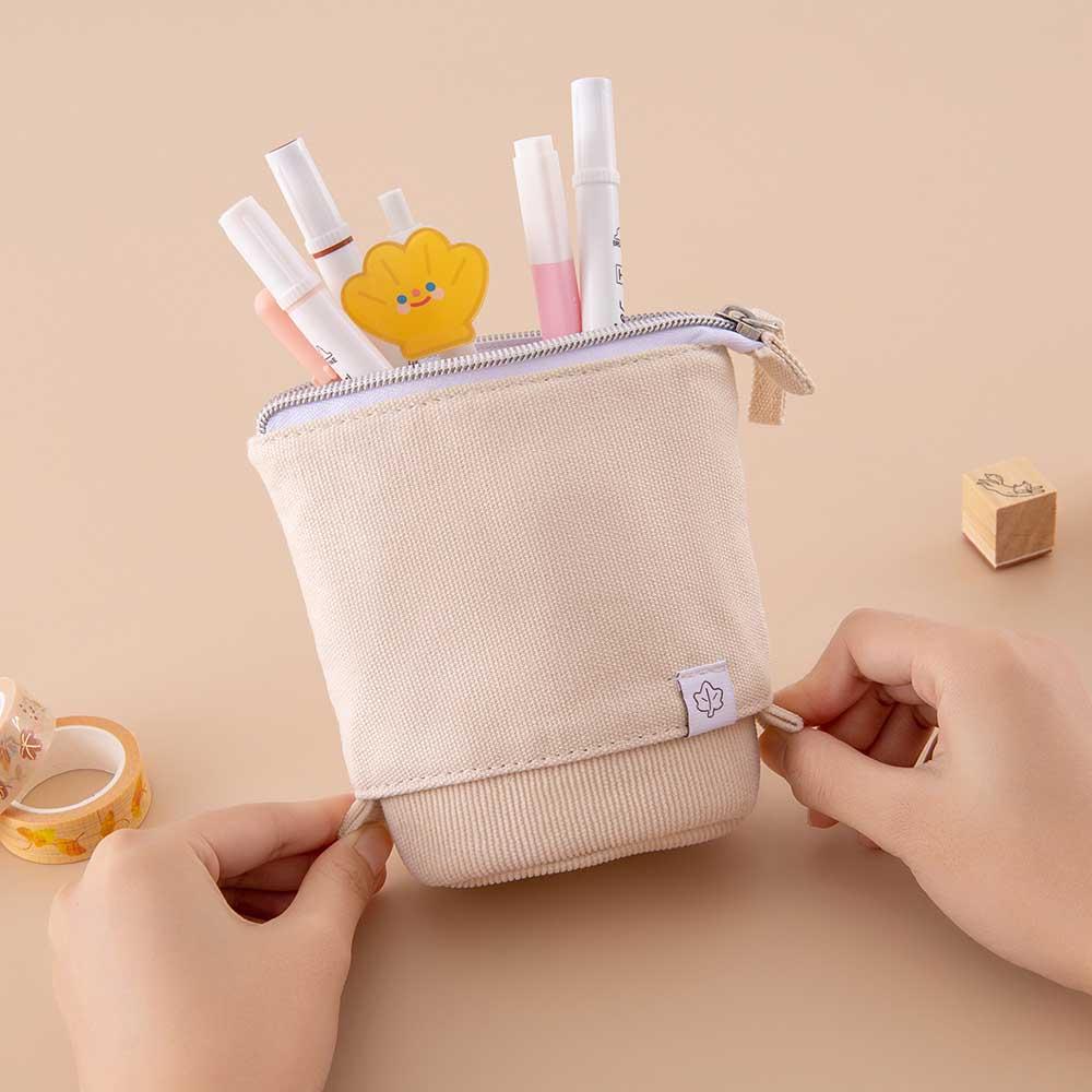 Tsuki ‘Maple Dreams’ Pop-Up Pencil case in stone held in hands with Tsuki ‘Maple Dreams’ Washi Tapes and Tsuki ‘Maple Dreams’ Bullet Journal stamp on beige background