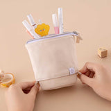 Tsuki ‘Maple Dreams’ Pop-Up Pencil case in stone held in hands with Tsuki ‘Maple Dreams’ Washi Tapes and Tsuki ‘Maple Dreams’ Bullet Journal stamp on beige background