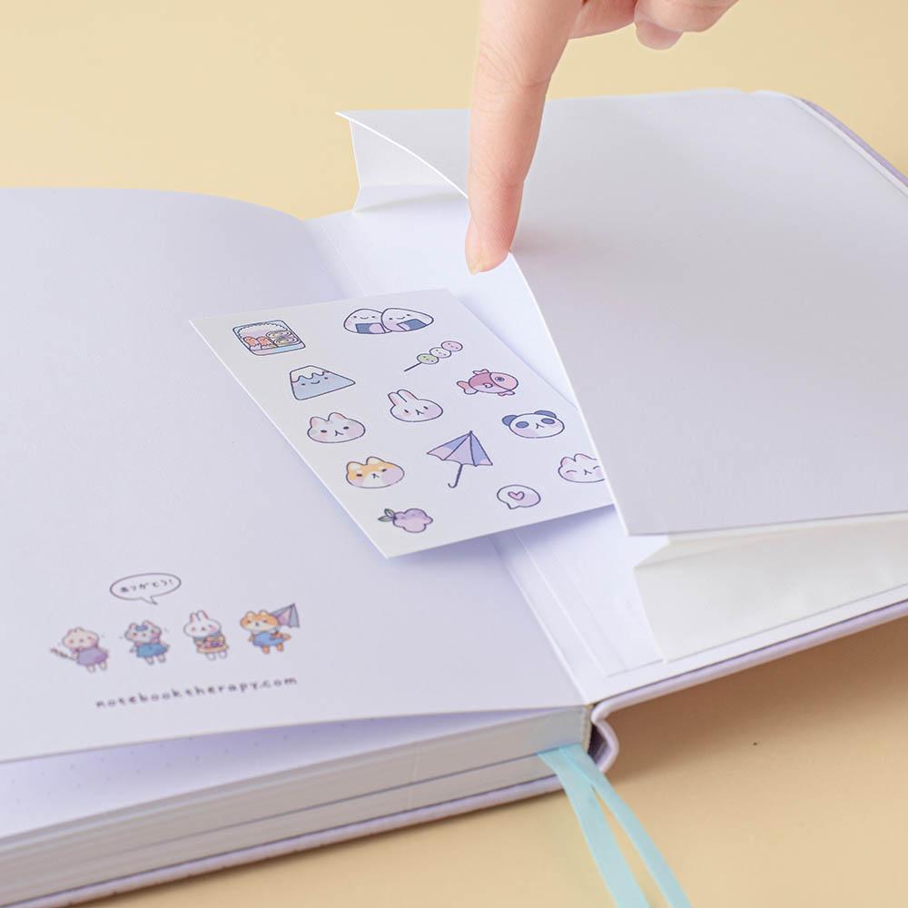 Close up of open back page pocket of Tsuki Four Seasons: Summer Edition Bullet Journal designed with @milkkoyo with free sticker sheet on honey yellow background