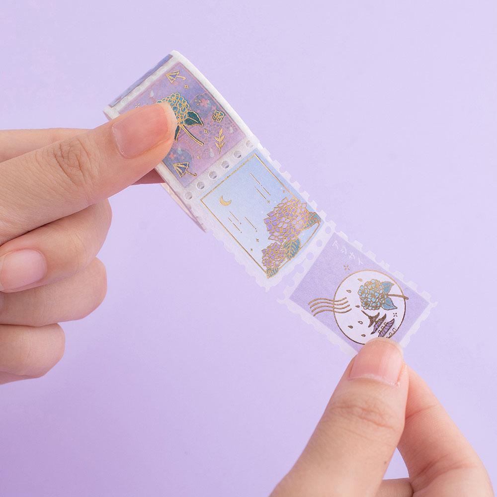 Tsuki Endless Summer Washi Stamp Tape roll held in hands on lilac background