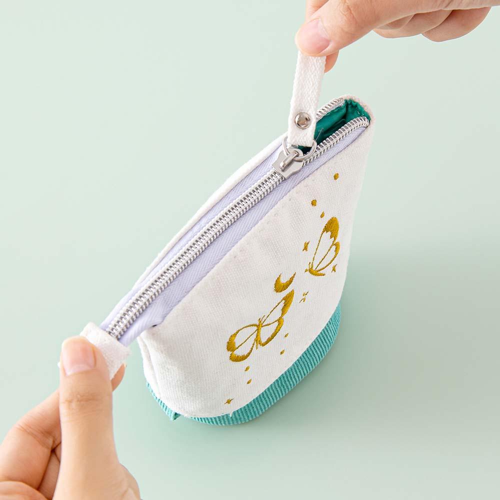 Tsuki ‘Flutter + Dream’ Pop-Up Pencil Case by Notebook Therapy x Pelinkan in teal with zip top held in hands in mint background