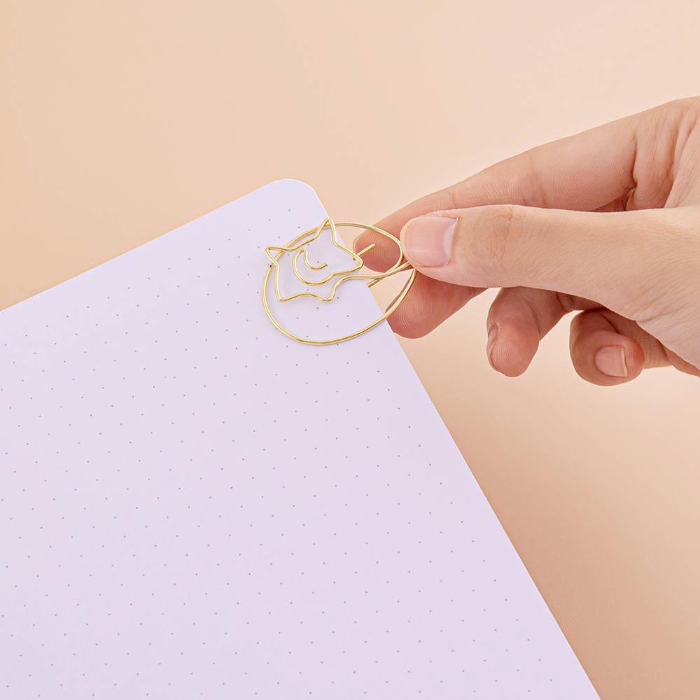 Close up of open page of Tsuki ‘Kitsune’ Limited Edition Fox Bullet Journal with free paperclip gift held in hand on beige background