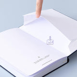 Open back page pocket of Tsuki ‘Cup of Galaxy’ Limited Edition Holographic Bullet Journal held in hand on light blue background
