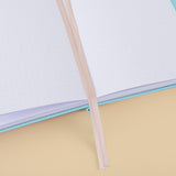 Close up of open Tsuki ‘Four Seasons: Autumn Edition’ Bullet Journal made with milkkoyo with two bookmark ribbons on light brown background