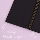 Close up of open Tsuki Black Paper Ringbound Bullet Journal with 150GSM black pages on lilac background