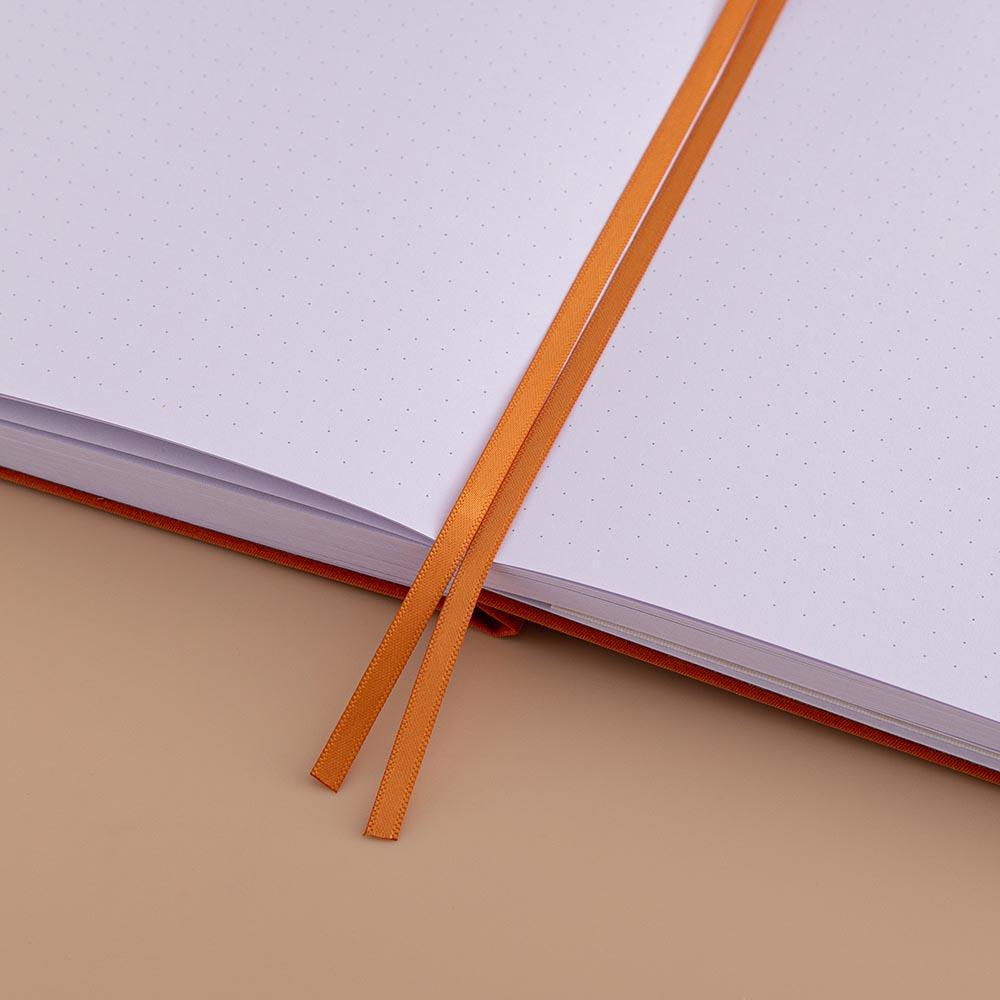 Close up of open page spread of Tsuki ‘Kitsune’ Limited Edition Fox Bullet Journal with two bookmark ribbons on beige background
