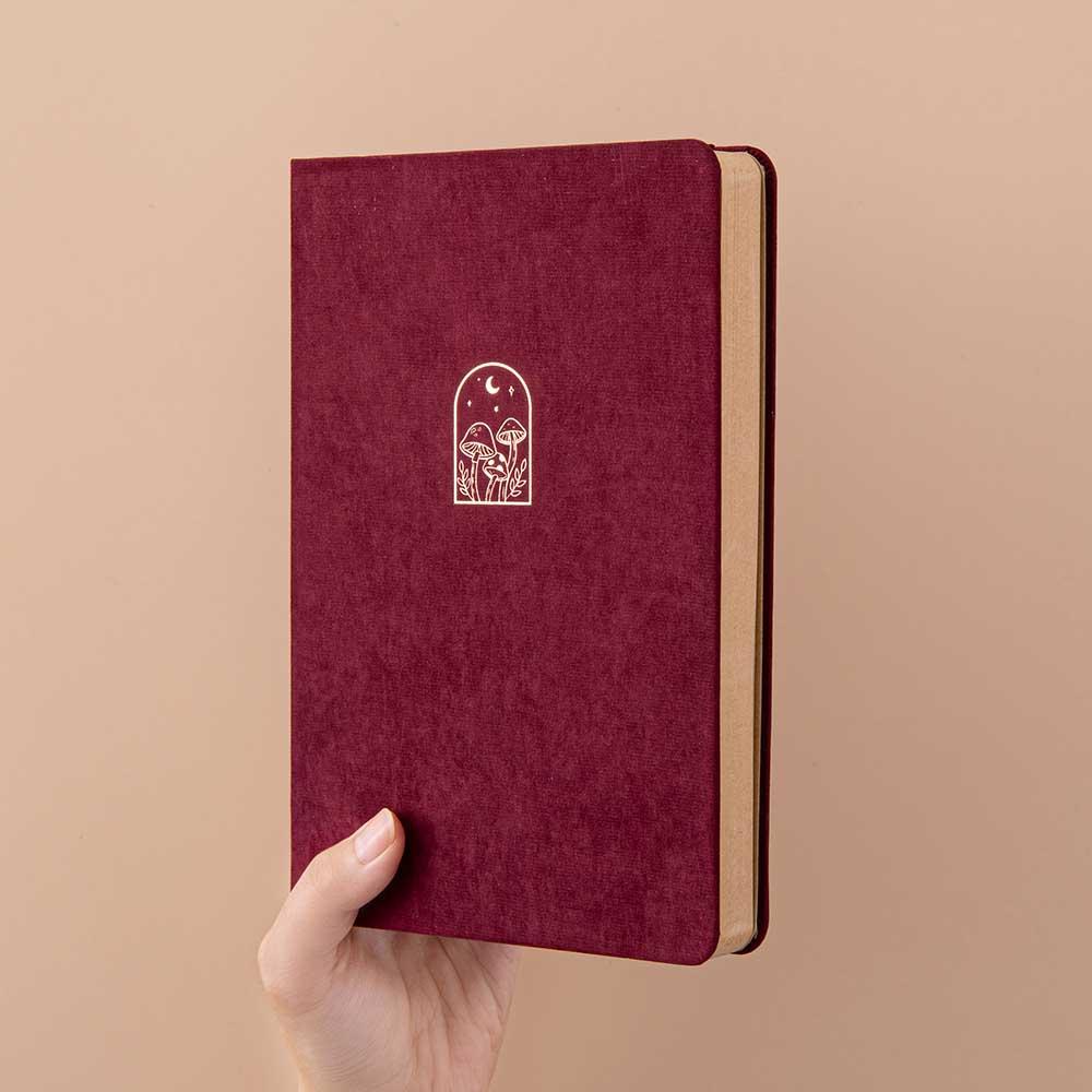 Tsuki Kraft Paper Limited Edition Bullet Journal in Kinoko held in hand at spine angle in beige background