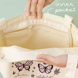 Close up of the inner pocket of Tsuki ‘Flutter + Dream’ Tote Bag by Notebook Therapy x Pelinkan held in hands in mint background