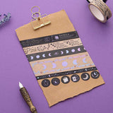 Tsuki ‘Moonlit Spell’ Washi Tape Set on kraft paper clipboard with lavender sprigs and black feather quill on purple background